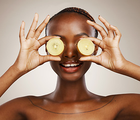 Image showing Kiwi, wellness and a black woman on a studio background for skincare, dermatology and a glow. Nutrition, hands and an African person or model with fruit for health, diet food and an organic snack