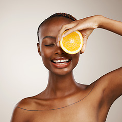 Image showing Black woman, orange fruits and beauty in studio for vitamin c, vegan cosmetics and facial on brown background. Happy model, citrus and nutrition for natural skincare, organic benefits and detox diet