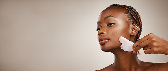 Image showing Skincare, black woman or gua sha on face for beauty, acne or blood circulation in studio on brown background. Cosmetic, person and facial product for lymphatic drainage, wellness and mock up for skin