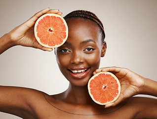 Image showing Woman, grapefruit and portrait of beauty in studio for vitamin c, vegan cosmetics and glow on brown background. Face, happy african model and citrus nutrition for healthy benefits of natural skincare