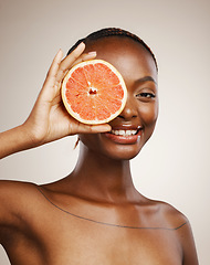 Image showing Happy woman, grapefruit and portrait of skincare in studio for vitamin c, vegan cosmetics and glow on brown background. Face, african model and citrus nutrition for healthy benefits of natural beauty