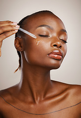 Image showing Woman, beauty and oil on face in studio for aesthetic skincare, dermatology and glow on brown background. African model, facial cosmetics and dropper of hyaluronic acid, liquid and serum for shine