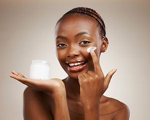 Image showing Portrait of black woman, happy or cream for wellness in studio with smile, natural cosmetics or glow. Dermatology, face or African girl model applying skincare lotion or creme on brown background