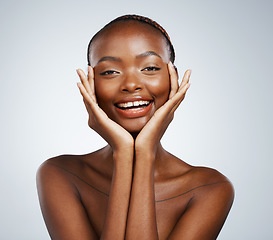 Image showing Portrait, beauty and hands on the cheek of a black woman in studio on a gray background for skincare or natural wellness. Smile, spa or luxury and a young model with cosmetic or antiaging treatment