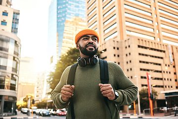 Image showing City, thinking and man with ideas, travel and vision with solution, planning and gen z with headphones. Person, hipster and guy with headset, outdoor or urban buildings with fashion or stylish outfit