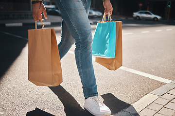 Image showing Legs, shopping bag and city person walking, travel and carry retail package, sales product and on outdoor journey. Urban foot steps, commerce market and person commuting with store discount purchase