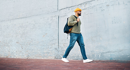 Image showing Student, walk and travel with man on wall, mockup and space in urban, campus or street in town. University, person and commute on path, road or journey to college in city with phone or backpack