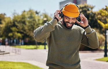 Image showing Music, headphones and happy man at garden outdoor, listening to audio online or hearing sound on internet podcast technology. Smile, streaming radio and person at park for freedom in nature in summer