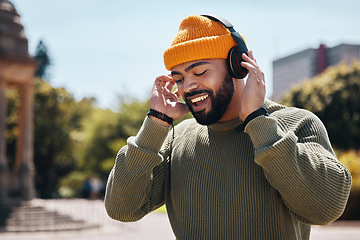 Image showing Music, headphones and happy man at park outdoor, listening to audio online on internet and hearing sound on podcast technology. Excited person streaming radio, dance in garden and freedom in nature