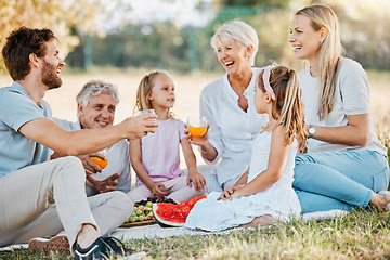 Image showing Park picnic, laughing and family children, parents and grandparents drinking orange juice, nature and funny joke. Grass field, grandpa and relax senior grandma, father or mother bond with garden kids