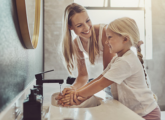 Image showing Bathroom, mother and child washing hands with water, soap and learning healthy hygiene together. Cleaning dirt, germs or bacteria on fingers, mom and girl in home for morning wellness, help and care.