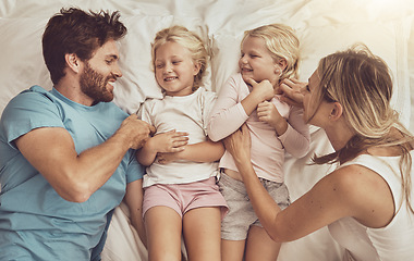 Image showing Family, children and parents in bed with smile, happiness and playing. Morning, tickle and funny with mom, dad and girls in bedroom, home and bonding together in top view, playful and affectionate