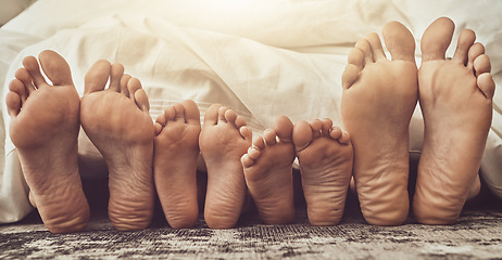 Image showing Feet, love and family in bed together to relax on a weekend morning in their home with flare. Mother, father and children with blankets sleeping in the bedroom to rest while dreaming closeup