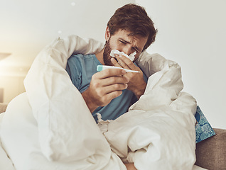 Image showing Thermometer, sneeze and sick man on sofa with headache, fever or influenza crisis at home. Anxiety, high temperature and male with toilet paper, worry or blowing nose in living room with covid fear