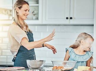 Image showing Mother and daughter, baking and smile with flour in kitchen and love by bonding. Happy family, fresh ingredients and fun in learning, cake and dessert or play for breakfast, snacks and food at home