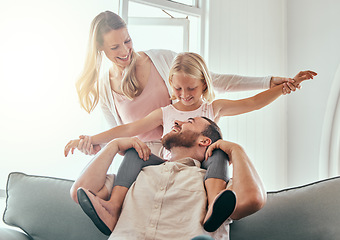 Image showing Parents, kid and airplane on couch, smile and playful for love, care or bonding in living room at family home. Father, mother and daughter with plane game, excited and relax on lounge sofa in house