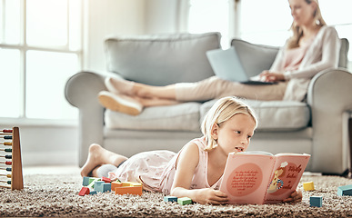 Image showing Girl child, home and reading book for learning, language development and mother work from home in living room. Family, kid and English story, school education and relax on floor with mom on sofa
