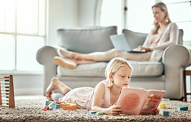 Image showing Child, floor and reading book for learning, language development and mother work from home in living room. Girl or kid with English story, education and relax on carpet with mom or family on sofa