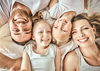 Image showing Happy, smile and portrait of family on a bed for bonding and relaxing together at modern home. Happiness, love and top view of girl children laying with parents from Australia in bedroom at house.