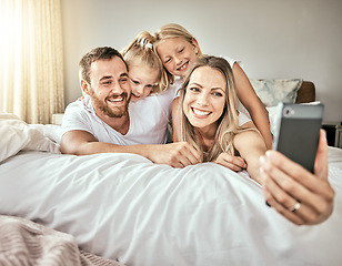 Image showing Selfie, happy and portrait of family on the bed for bonding and relaxing together at modern home. Smile, love and girl children laying and taking a picture with parents from Australia in bedroom.