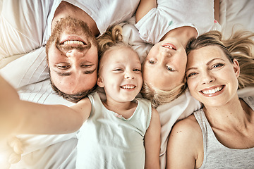 Image showing Happy, love and portrait of family on a bed for bonding and relaxing together at modern home. Happiness, smile and top view of girl children lying with parents from Australia in bedroom at house.