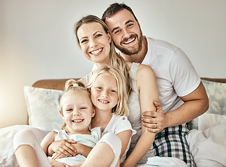 Image showing Happy, love and portrait of family on the bed for bonding and relaxing together at modern home. Happiness, smile and girl children sitting with mother and father from Australia in bedroom at house.