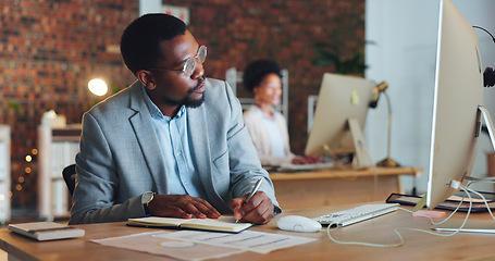 Image showing Planning, black man and writing notes in office with business agenda, administration or review of schedule. Businessman, notebook and report on computer research, information or reminder in journal