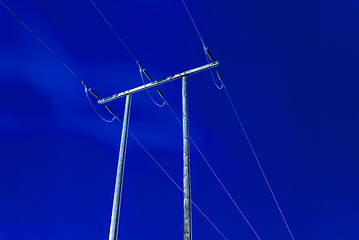 Image showing blue night sky with power lines on old wooden poles