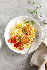 Image showing Couscous with chicken patties, cutlets and tomatoes, top down view