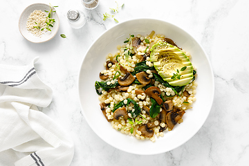 Image showing Couscous with avocado, spinach and sauteed champignon mushrooms with onion, top down view