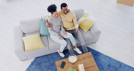 Image showing Black couple, top view and couch in living room, tv and relax with popcorn, movies and funny comedy. Man, woman and hug for bonding together, streaming and happy in lounge, couch and remote control