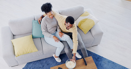 Image showing Couple, watching tv and eating popcorn in home, living room and date in apartment with comedy or movies. Happy, people and together on sofa with food to watch tv show or film or above lounge in house