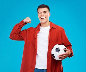 Image showing Portrait, football and happy man with strong muscle in studio isolated on a blue background. Face, soccer and excited person flex bicep for power, sports and success in competition, winner or fitness