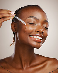 Image showing Skincare, woman and smile with dropper on studio background for wellness in cosmetics, beauty or serum. African, person or model by happy, face or relaxed for facial treatment for anti aging oil