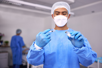 Image showing Man, doctor and syringe for vaccine, injection or patient flu shot in surgery room at hospital. Male person, nurse or medical professional with needle and vial for vaccination or antibiotic at clinic