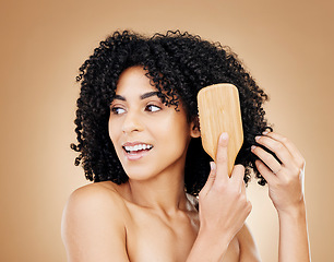Image showing Hair, woman brush curls and beauty, routine or treatment for shine, cosmetic care and smile on studio background. Wellness, haircare and growth with strong texture and bamboo tools, volume and afro