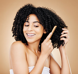 Image showing Curly, hair comb and smile of woman in studio for beauty, natural growth or coil texture on brown background. Happy model, haircare tools and brush afro for salon aesthetic, keratin cosmetics or care