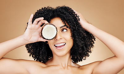 Image showing Beauty studio face, happy woman and coconut for skin detox, natural wellness treatment or facial makeup. Happiness, fruit benefits and aesthetic person with food skincare product on brown background