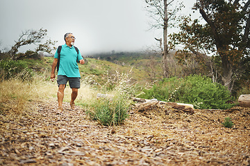 Image showing Mountain, hiking and senior man in nature, countryside or exercise in woods for fitness, cardio health or wellness. Retirement, workout and person walking in forest, environment or relax in landscape