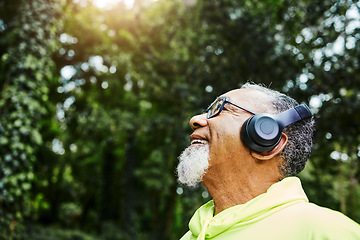 Image showing Headphones, nature and senior man hiking for health, wellness or cardio training on a mountain. Smile, happy and excited elderly male person breathing for outdoor trekking in the woods or forest.