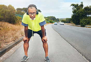 Image showing Tired, road and senior man with fitness, fatigue and exercise with wellness, workout and training. Runner, athlete and old person with headset, outdoor and exhausted with burnout, breathing and relax