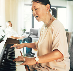 Image showing Singing, piano and senior woman playing for music with husband in living room for bonding and entertainment. Instrument, practice and elderly Asian man and woman in retirement with keyboard at home.