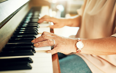 Image showing Hands, closeup and woman playing piano for music in living room for musical talent practice. Instrument, song and zoom of senior female person in retirement enjoying keyboard at modern home.