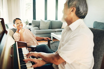 Image showing Happy, piano and senior man playing for music in living room with wife for bonding, entertainment or having fun. Instrument, smile and elderly Asian couple in retirement enjoy keyboard at modern home