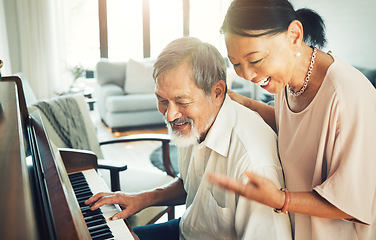 Image showing Senior couple playing piano for music in living room for bonding, entertainment or having fun. Happy, smile and elderly Asian man and woman in retirement enjoying keyboard instrument at modern home.