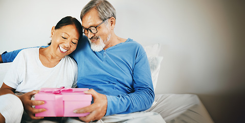 Image showing Happy couple in bed, senior or hug for gift for anniversary, care or love in home, house or retirement. Giving, Asian man or excited mature woman with birthday present box for romance in bedroom