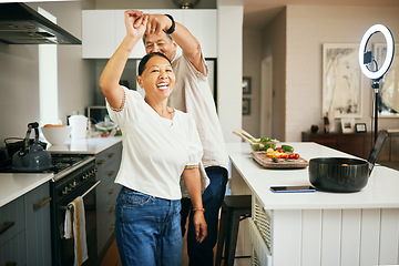 Image showing Happy couple, together and dancing while cooking in kitchen for fun, energy or bond in romance. Asian people, married and smile for love, excited or laugh with spin with preparation of dinner in home