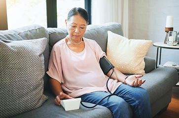 Image showing Blood pressure, healthcare and senior woman in living room with equipment for hypertension. Sick, illness and elderly female person in retirement with medical tool in the lounge of modern home.