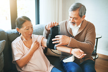 Image showing Blood pressure, medical and senior couple in living room with equipment for hypertension. Sick, love and elderly man with healthcare tool for woman in retirement in the lounge of modern home together