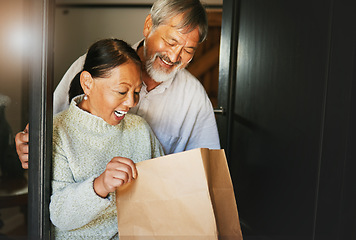 Image showing Couple, online shopping or package with smile for delivery, cargo or present at front door of home. Asian, senior man or woman with gift bag, ecommerce or surprise product in house or apartment